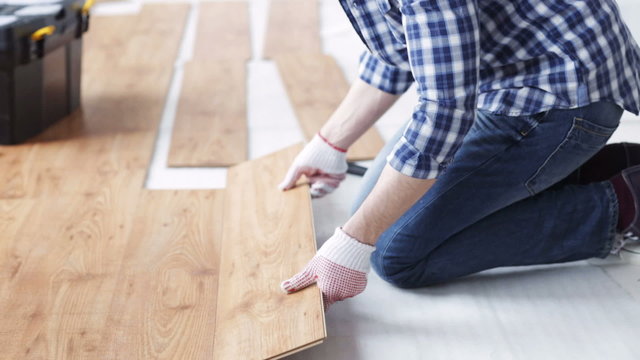 close up of man installing wood flooring