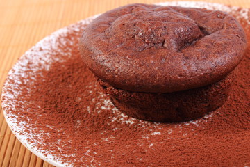 Baked chocolate muffins with cocoa on white plate