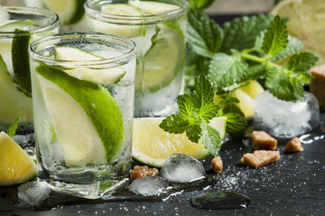 Mojito cocktail with lime and ice, black background, selective f