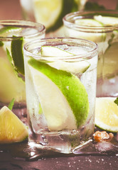 Mojito cocktail with lime and ice, black background, toned, sele