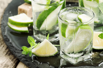 Mojito cocktail with lime and ice, black background, selective f