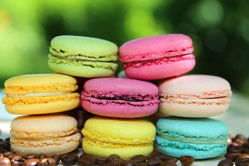 Fototapeta na wymiar Colorful french macarons with coffee on the nature background