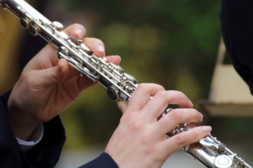 Girl playing the clarinet during a concert in the street