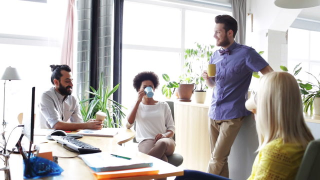 happy creative team drinking coffee in office