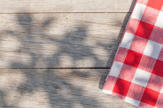 Empty wooden garden table with tablecloth