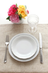 Place setting with yellow and pink roses