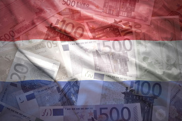 Obraz premium colorful waving dutch flag on a euro money background
