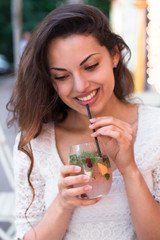 beautiful smiling woman drinking cold lemonade berry, outdoor