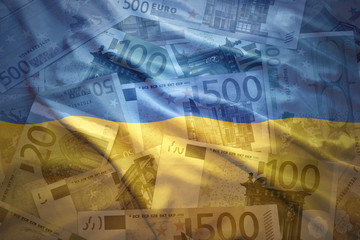 colorful waving ukrainian flag on a euro money background