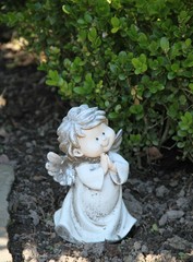 Kleiner Engel betet auf einem Grab
