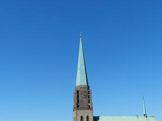 Strahlend blauer Himmel über der Altstädter Nicolaikirche mit Kirchturmspitze im Sonnenschein in...