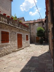 Fototapeta na wymiar Мощеная улица старого города с близко стоящими каменными домами
