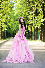 Fototapeta premium Fashion Woman Outdoors. Fashion Girl on Summer Greenery Background