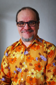 positive senior man in a vintage shirt  with a beard and mustach