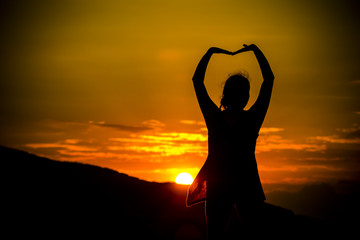 female yoga exercising at the sunset