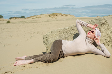 Woman on vacation basking in the sun in clothes