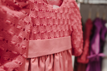 A little girl dress hanging in a children clothing store.