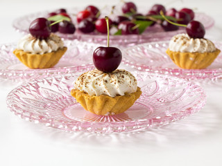 Cupcakes (three cakes) with cherries and whipped cream