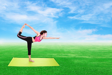 Young woman doing yoga exercise with yoga mat