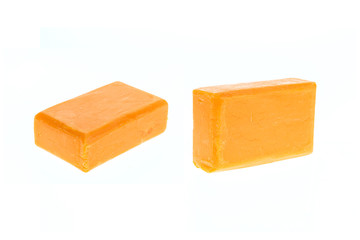 Close up bar of orange carrot soap isolated on white