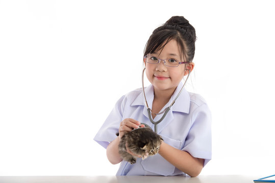 Little asian girl playing veterinarian with kitten