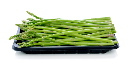 asparagus in black plastic tray on a white background