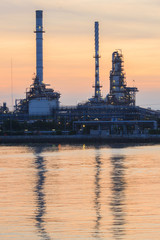 Petrochemical plant at sunrise with reflection on water