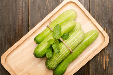 Fresh cucumber on wooden plate