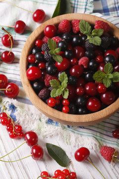 Berry mix in a wooden bowl close-up. Vertical
