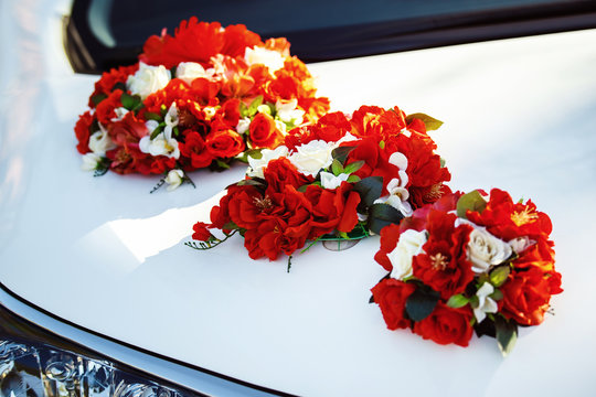 image of wedding car decoration with red and white flowers