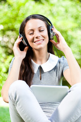 Young woman listening music in park