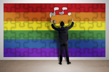 Business man assemble puzzle of gay flag
