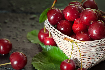 Sweet Cherry with Water droplets on black plate