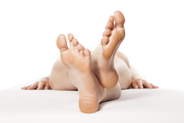 young barefoot woman lying on a bed with the focus on her feet