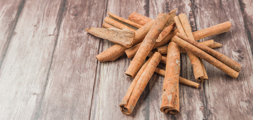 Cinnamon stick spice over weathered wooden background
