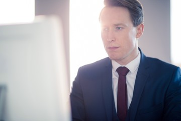 Fototapeta premium Serious businessman typing on computer