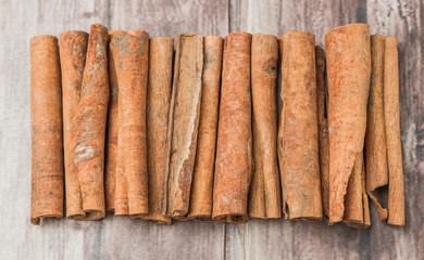 Cinnamon stick spice over weathered wooden background