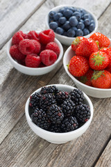 blackberries in bowl and fresh garden berries, top view