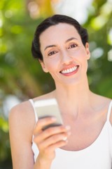 woman in white looking at her phone 