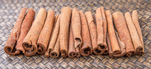 Cinnamon stick spice over wicker background