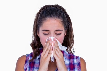 Pretty brunette woman blowing her nose 