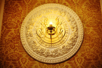 decorative bas-relief on the wall under the lamp