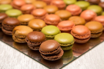 Macarons colorati in fila su vassoio specchiato