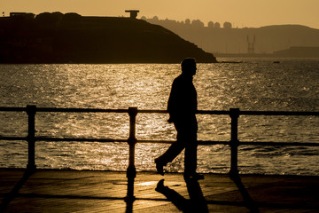 Hombre caminando al atardecer por la ciudad
