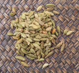 Cardamom spices over wicker background
