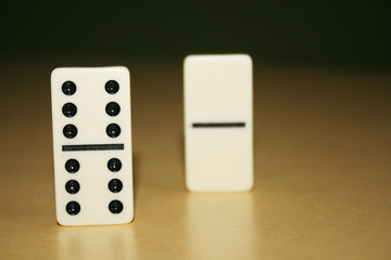 Close up picture of dominos, one from the crowd