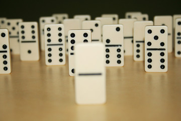 Close up picture of dominos, one from the crowd