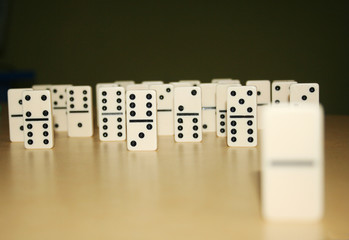 Close up picture of dominos, one from the crowd