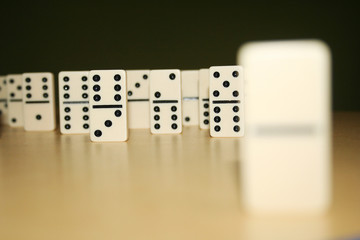 Close up picture of dominos, one from the crowd