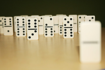 Close up picture of dominos, one from the crowd